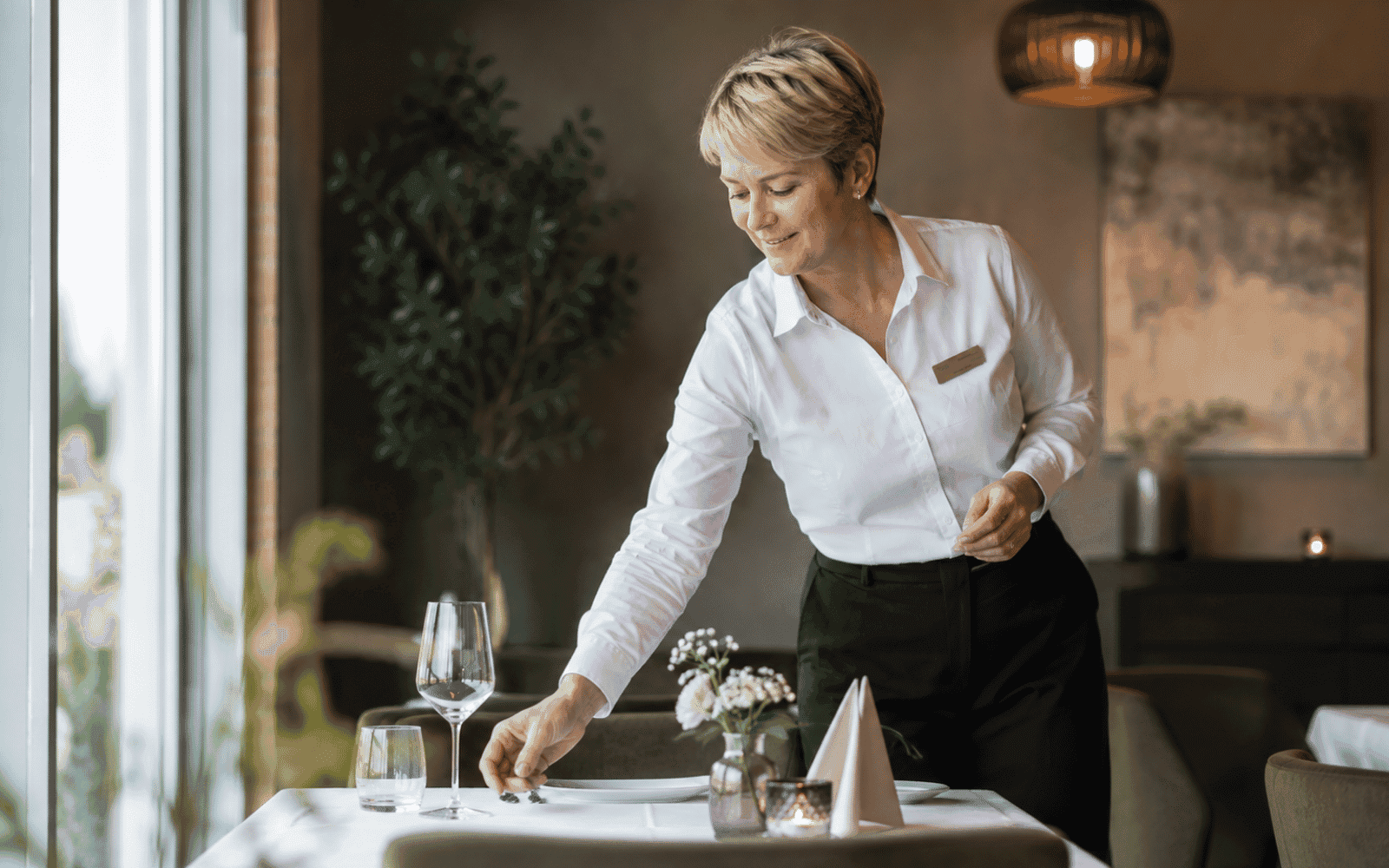 Servitør som serverer mat ved et restaurantbord