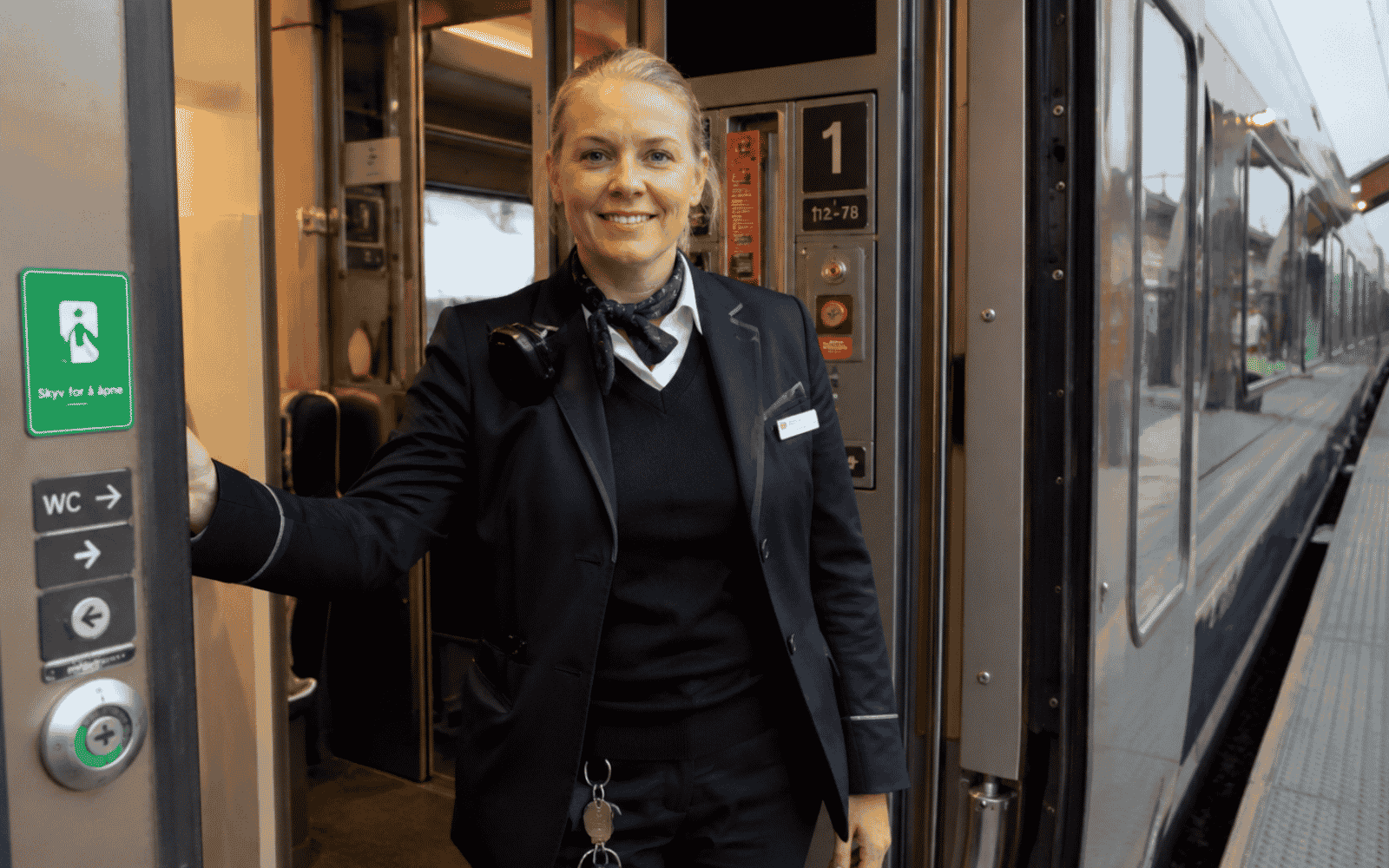 Konduktør som står ved døren på et tog